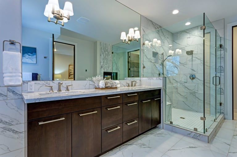 Master bathroom with Carrara marble tile surround and modern glass walk in shower
