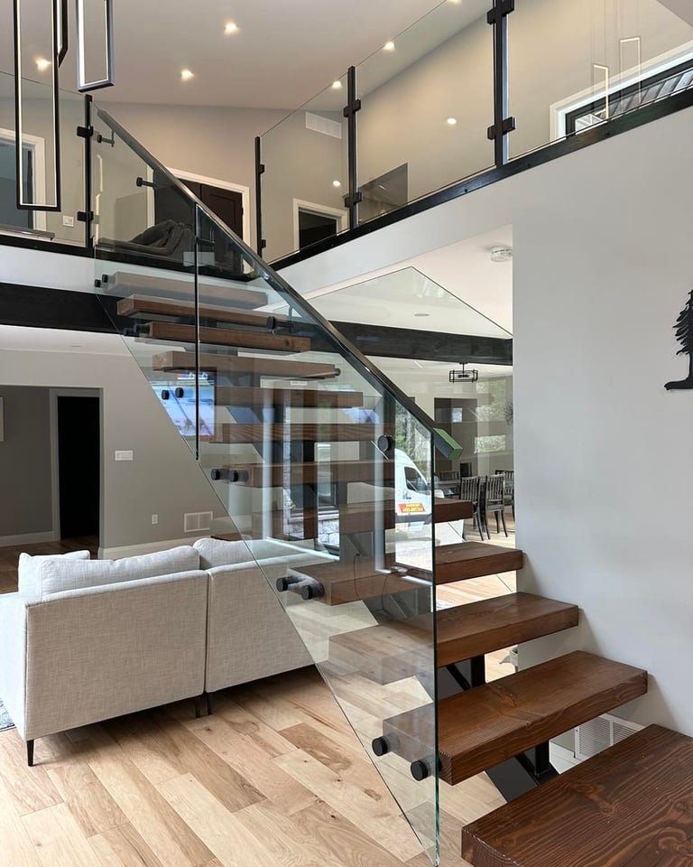 Modern two-story open loft interior with wooden floating staircase and glass railings