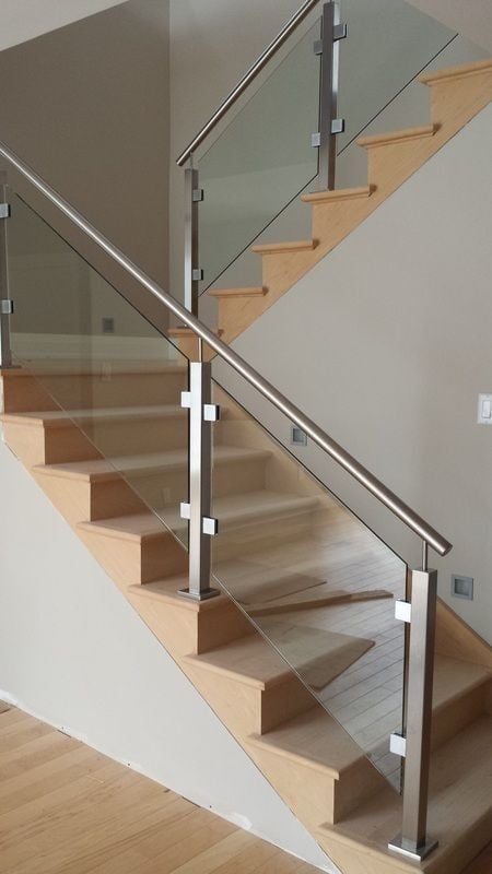 Modern wooden staircase with glass and metal railing