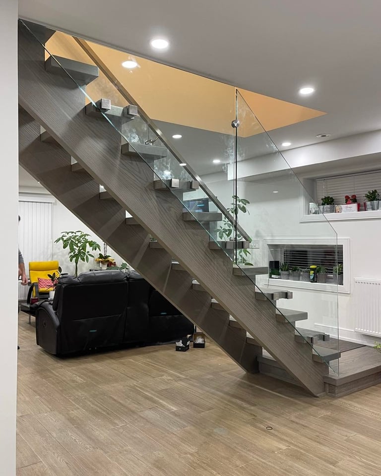 Modern staircase with glass railing and wood steps in contemporary home interior with yellow ceiling detail